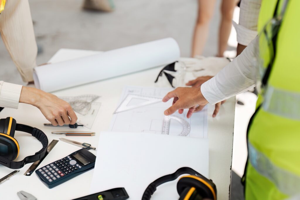 Architect collaboration on Construction Plan at a Worksite with Blueprint and Tools